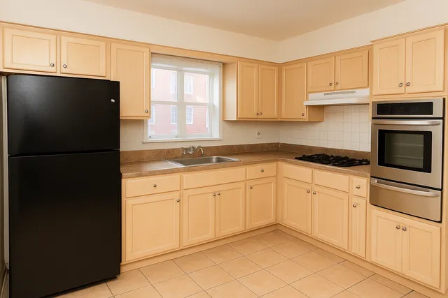 a kitchen with white cabinets and refrigerator