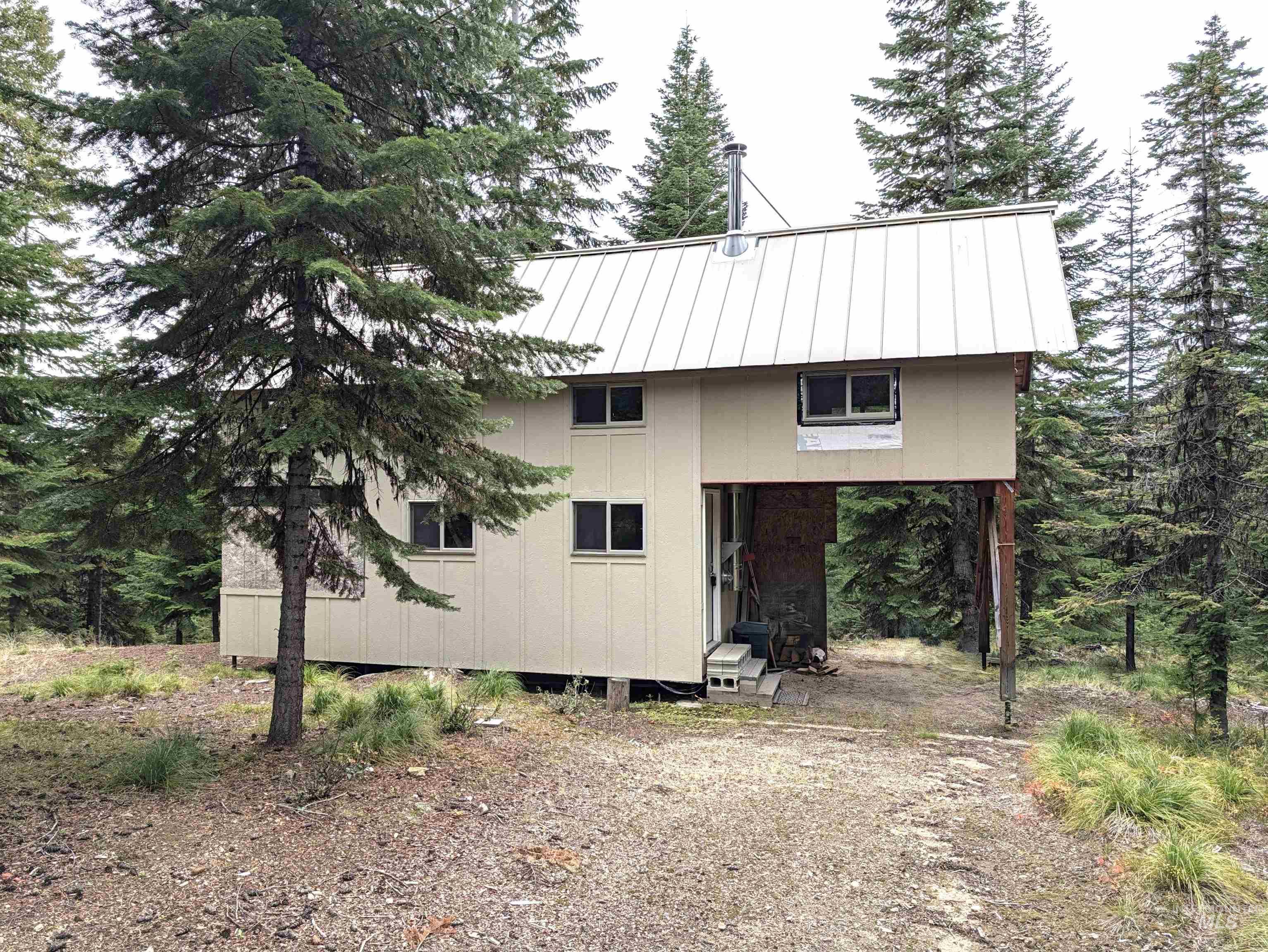 524 Rhett Creek Road Elk City, ID 83525 - Photo 1 of 23 Two-story residence with a metal roof and light-colored siding, surrounded by mature trees