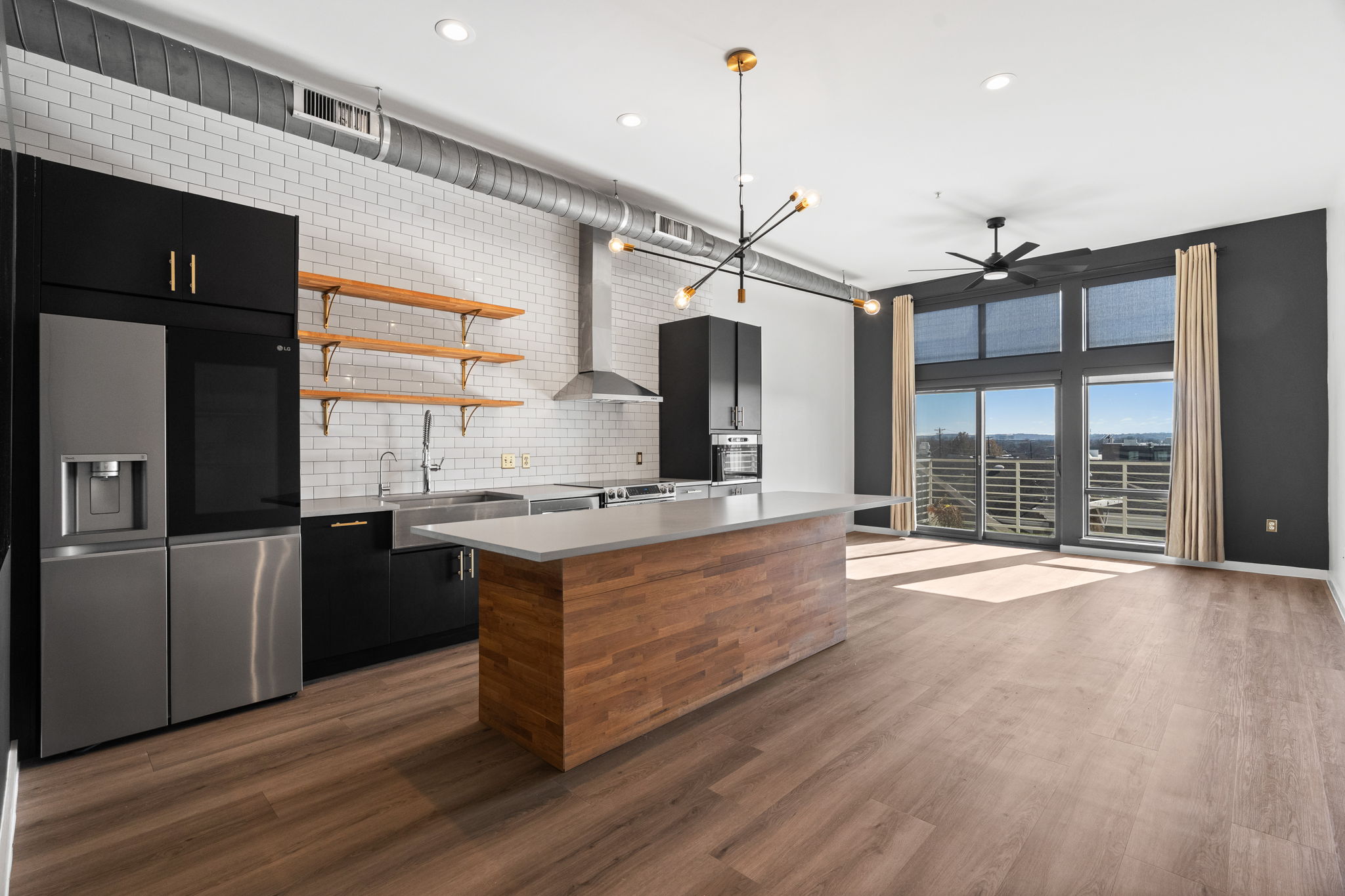 a kitchen with stainless steel appliances granite countertop a sink a stove and a wooden floors