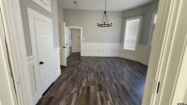 a view of empty room with wooden floor and window