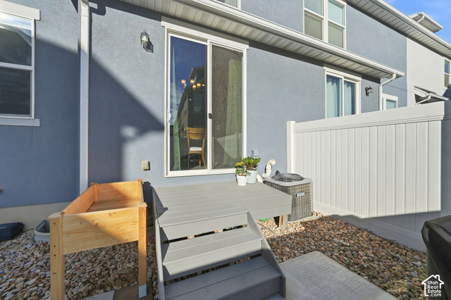 1081 Bowery Way Mapleton, UT 84664 - Photo 29 of 41 Exterior featuring a sliding glass door, composite deck with steps, gravel landscaping, and a white vinyl privacy fence