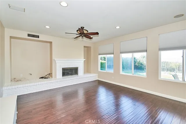 a view of an empty room with a fireplace and a window