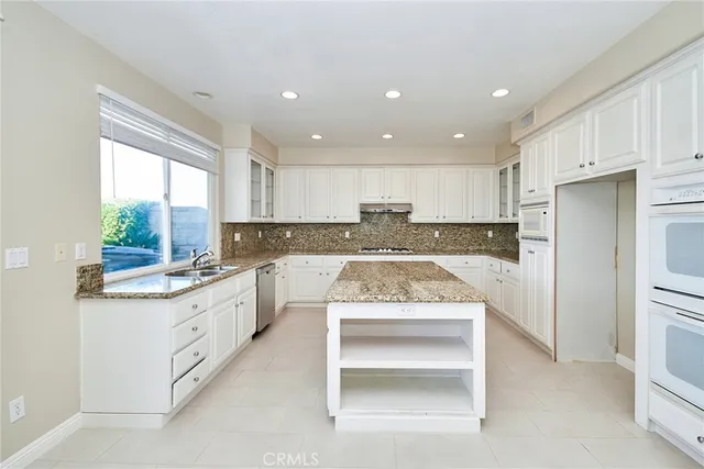 a kitchen with granite countertop white cabinets and white appliances
