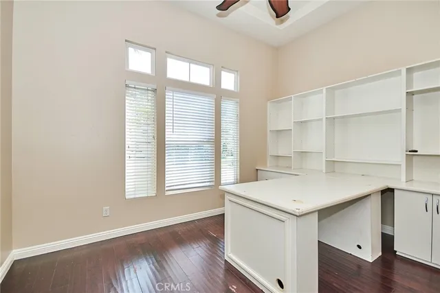 a view of a hallway with wooden floor and windows
