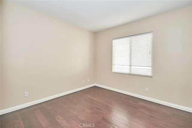 an empty room with wooden floor and window