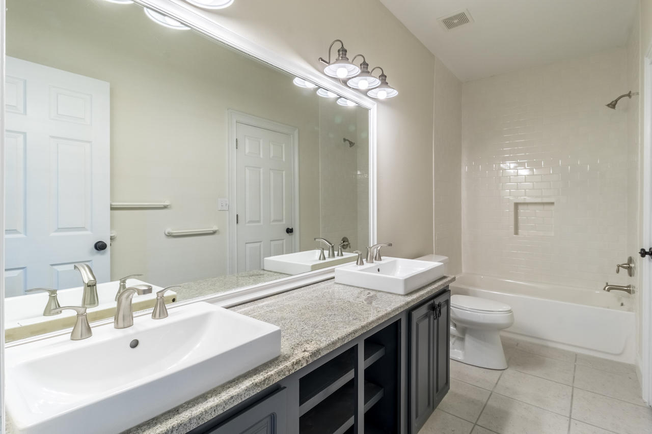72 Carolyn Lane Santa Rosa Beach, FL 32459 - Photo 15 of 25 a bathroom with a granite countertop sink a toilet a large mirror and shower