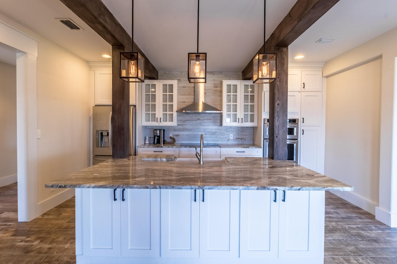 72 Carolyn Lane Santa Rosa Beach, FL 32459 - Photo 6 of 25 a kitchen with kitchen island granite countertop a sink cabinets and wooden floor