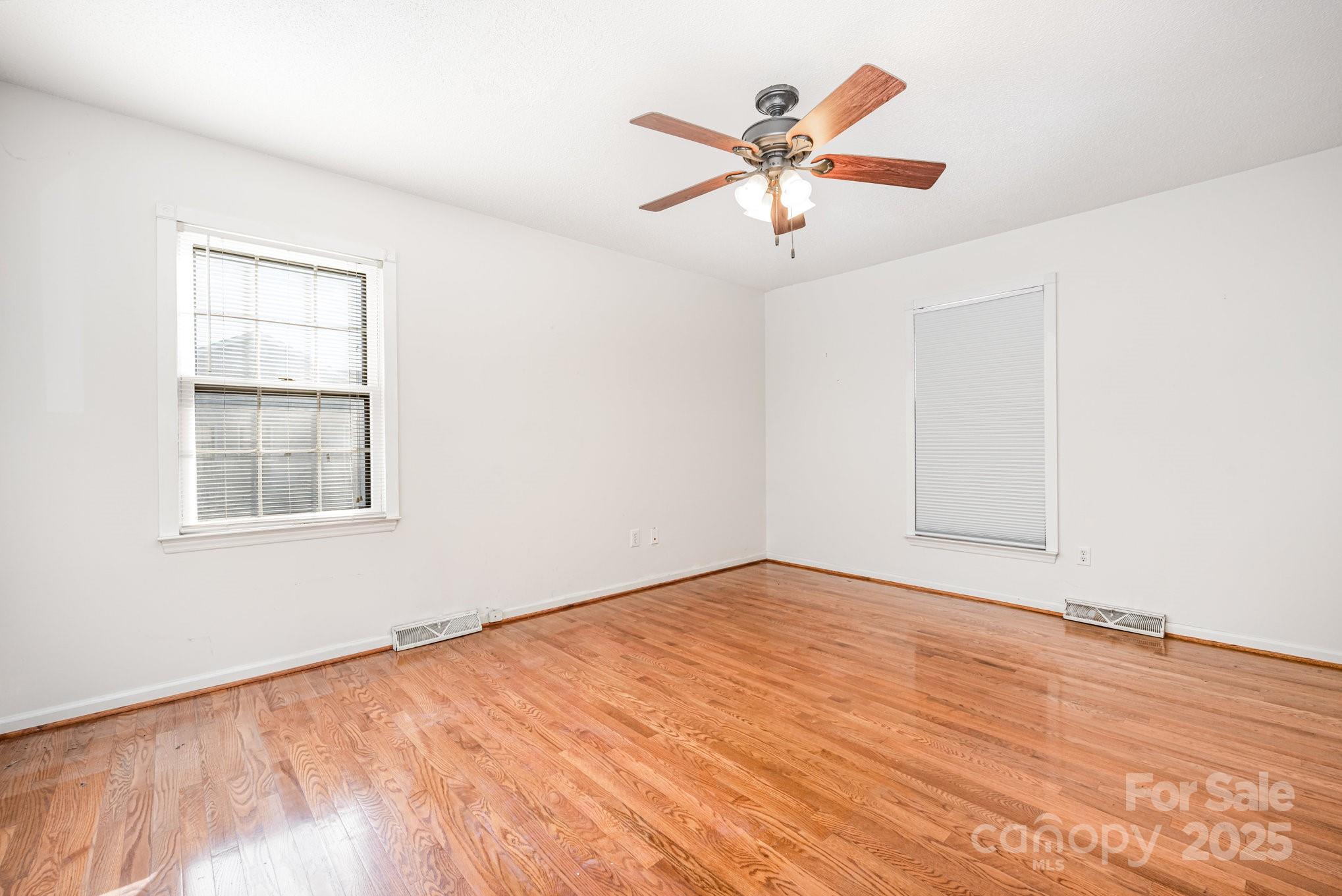 7615 Alexander Road Charlotte, NC 28270 - Photo 13 of 19 an empty room with wooden floor fan and windows