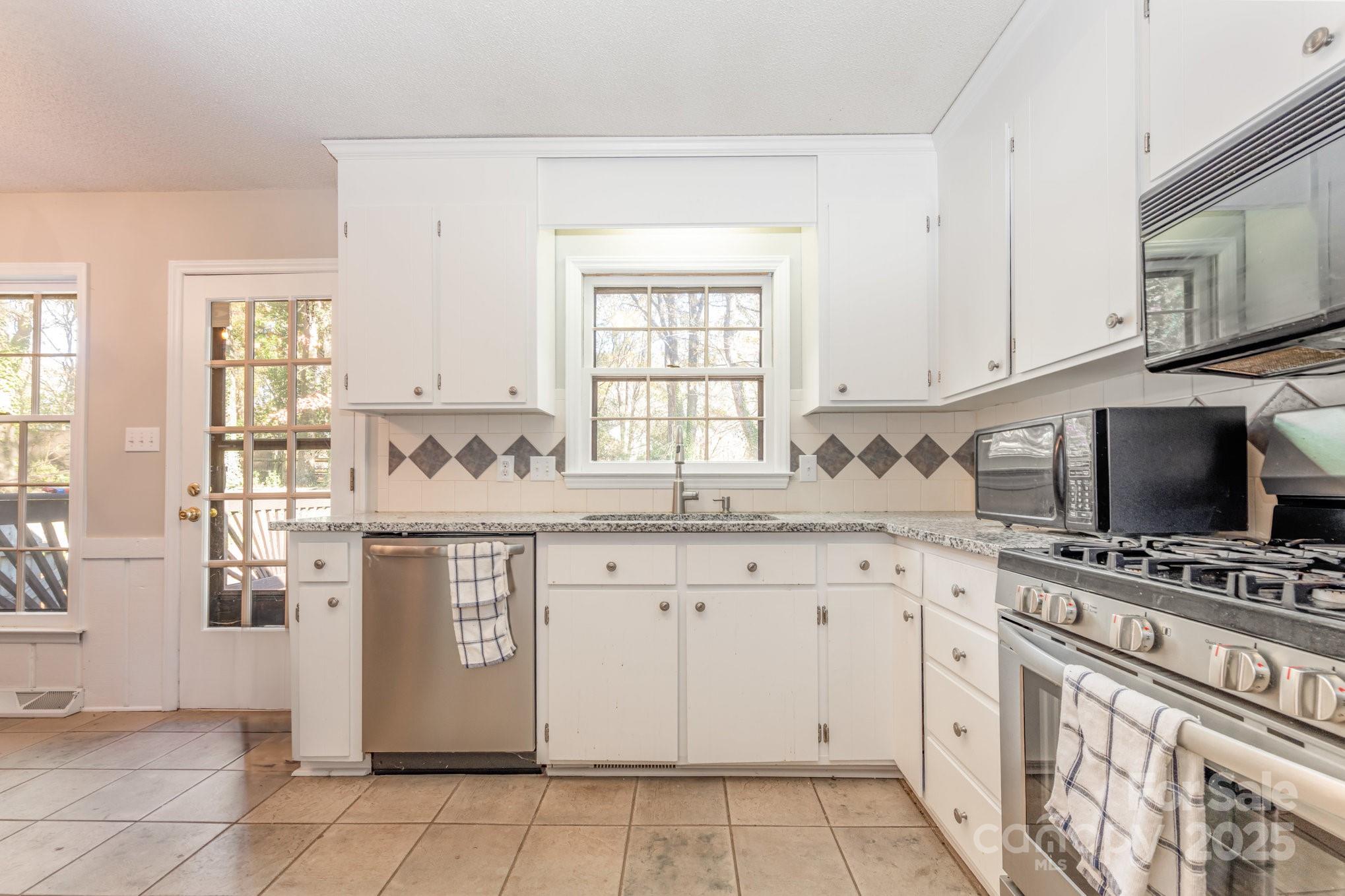 7615 Alexander Road Charlotte, NC 28270 - Photo 8 of 19 a kitchen with granite countertop a sink stove and cabinets