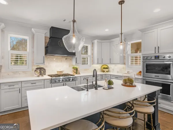 a kitchen with a sink a stove and chairs