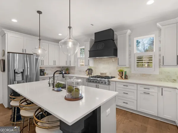 a kitchen with a sink a stove and chairs