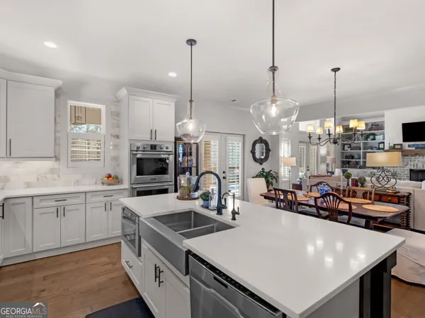 a kitchen that has a lot of cabinets and stainless steel appliances