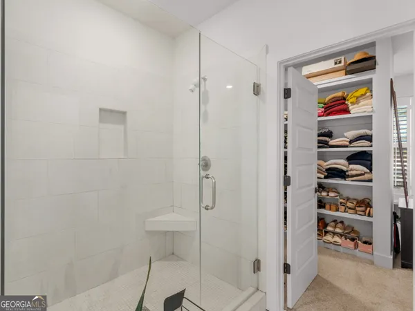 a view of walk in closet with clothes and shoes