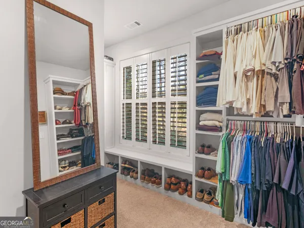 a view of walk in closet with clothes and shoes