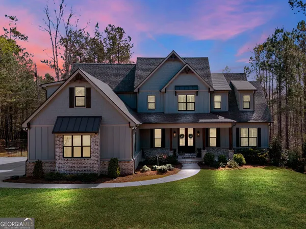 a front view of a house with garden and trees