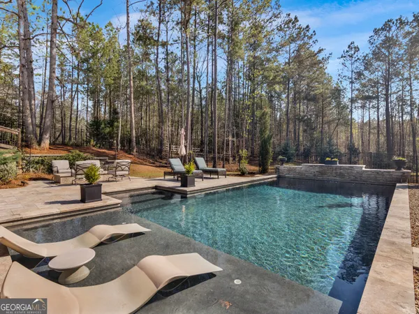 a front view of a house with swimming pool having outdoor seating
