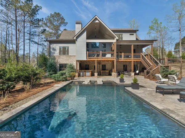a front view of a house with swimming pool having outdoor seating