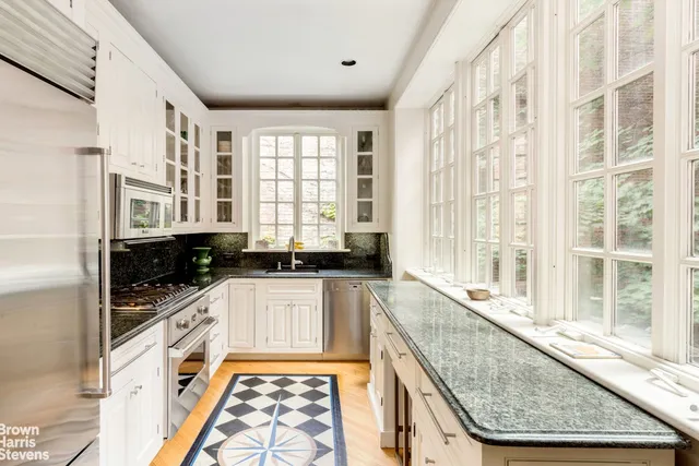 a large kitchen with granite countertop a large window and a sink