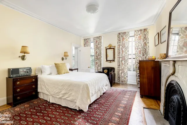 a bedroom with a bed a couch and a dresser next to a window