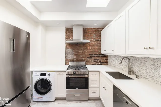 a kitchen with a stove sink and cabinets