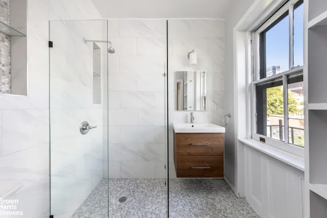 a bathroom with a shower sink and mirror