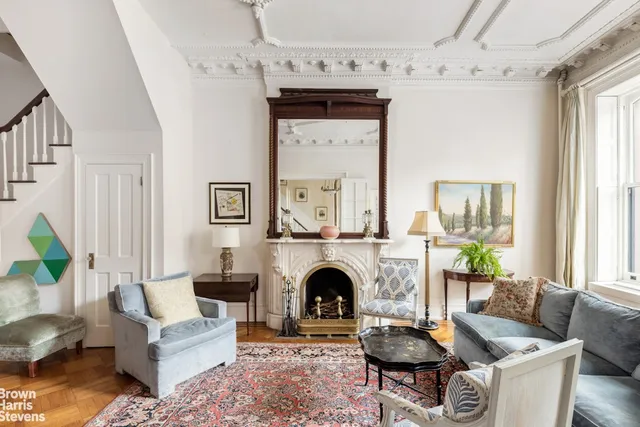 a living room with furniture a fireplace and a chandelier