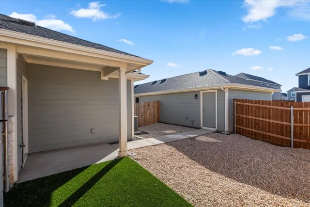 a view of a house with a yard and wooden fence