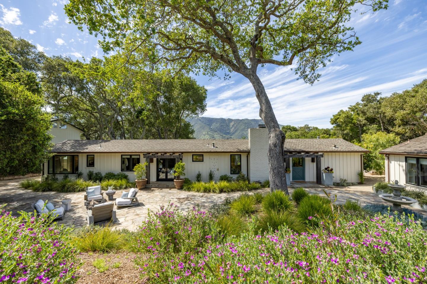 58 La Rancheria Carmel Valley, CA 93924 - Photo 1 of 36 a front view of a house with garden and sitting area