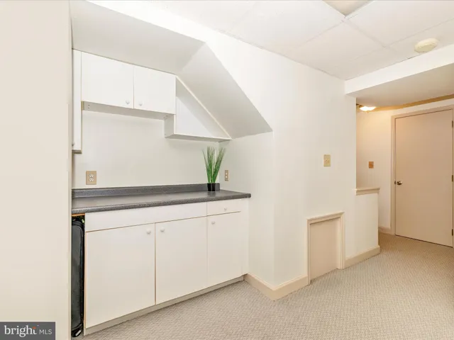 a kitchen with white cabinets and white appliances