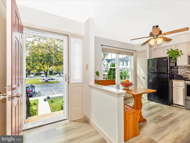 a kitchen view with a refrigerator and wooden floor