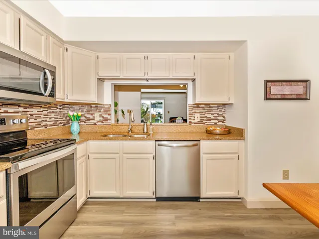 a kitchen with white cabinets and appliances