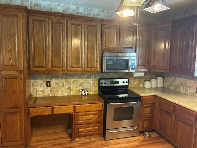a kitchen with granite countertop cabinets stainless steel appliances and a counter space