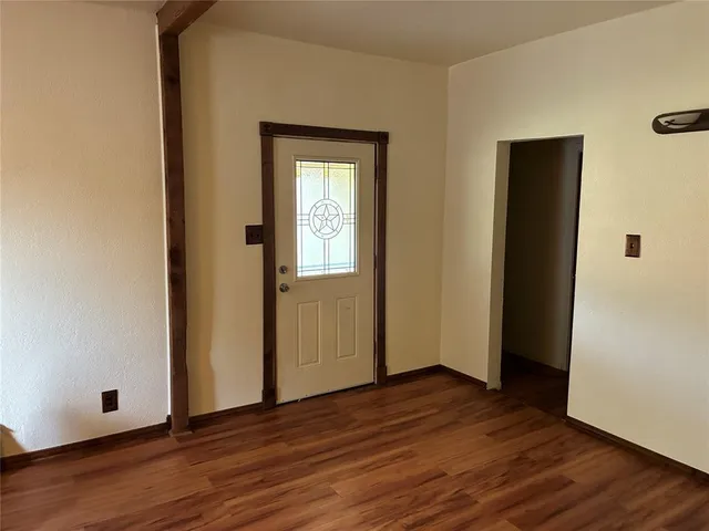 an empty room with wooden floor and closet