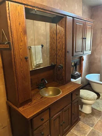 a bathroom with a sink a toilet and a mirror