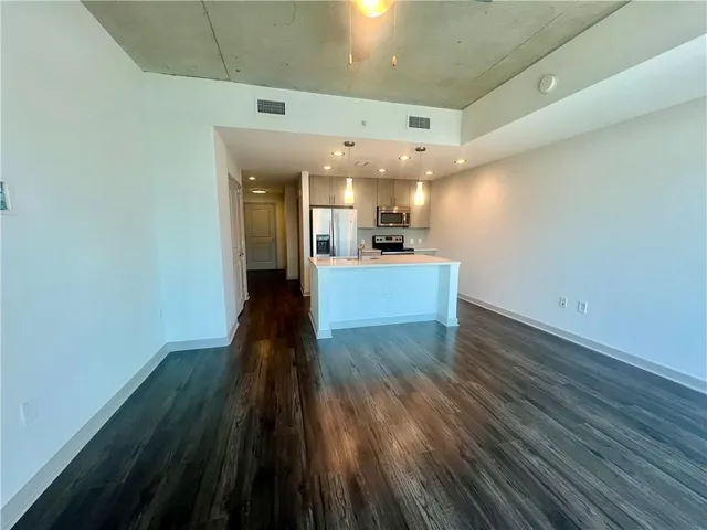 a view of a kitchen with wooden floor and electronic appliances
