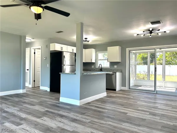 a large kitchen with stainless steel appliances kitchen island a chandelier