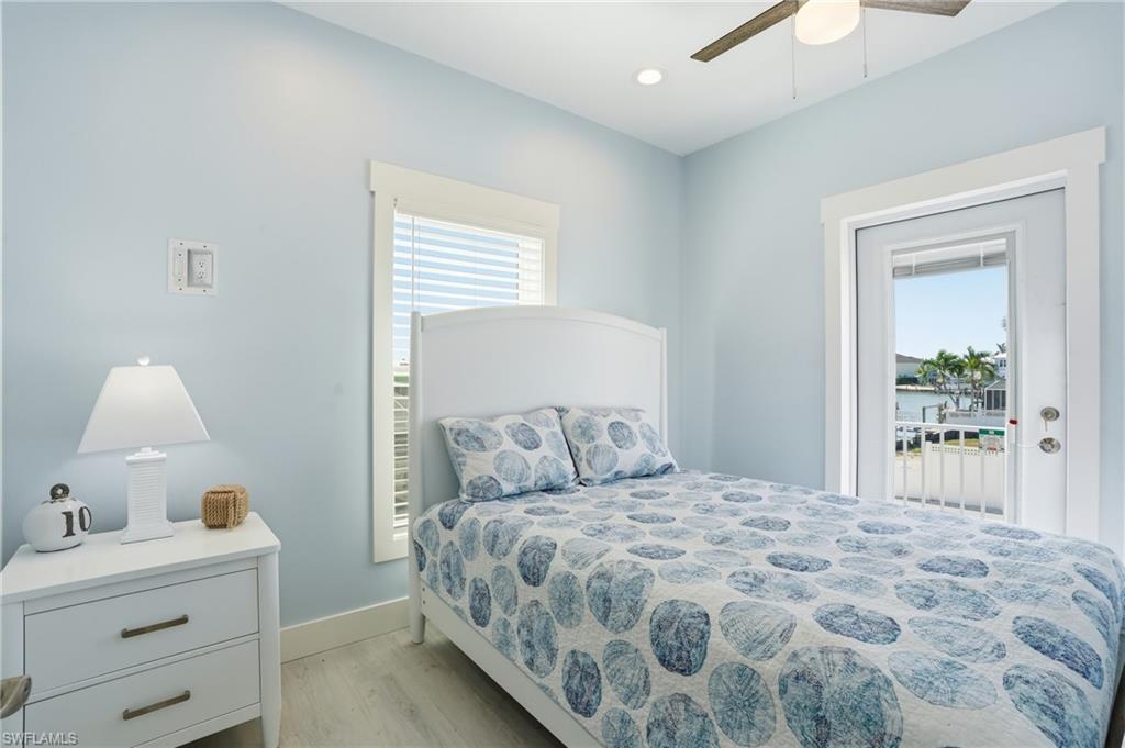 1 Fairview Boulevard Fort Myers Beach, FL 33931 - Photo 20 of 48 Light blue wall paint and white trim, featuring a ceiling fan, recessed lighting, and wood-finish flooring - Virtually Edited Image