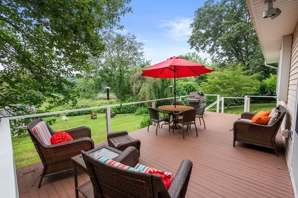 96 Bridge Street Medfield, MA 02052 - Photo 32 of 41 a view of a patio with couches chairs potted plants and a palm tree