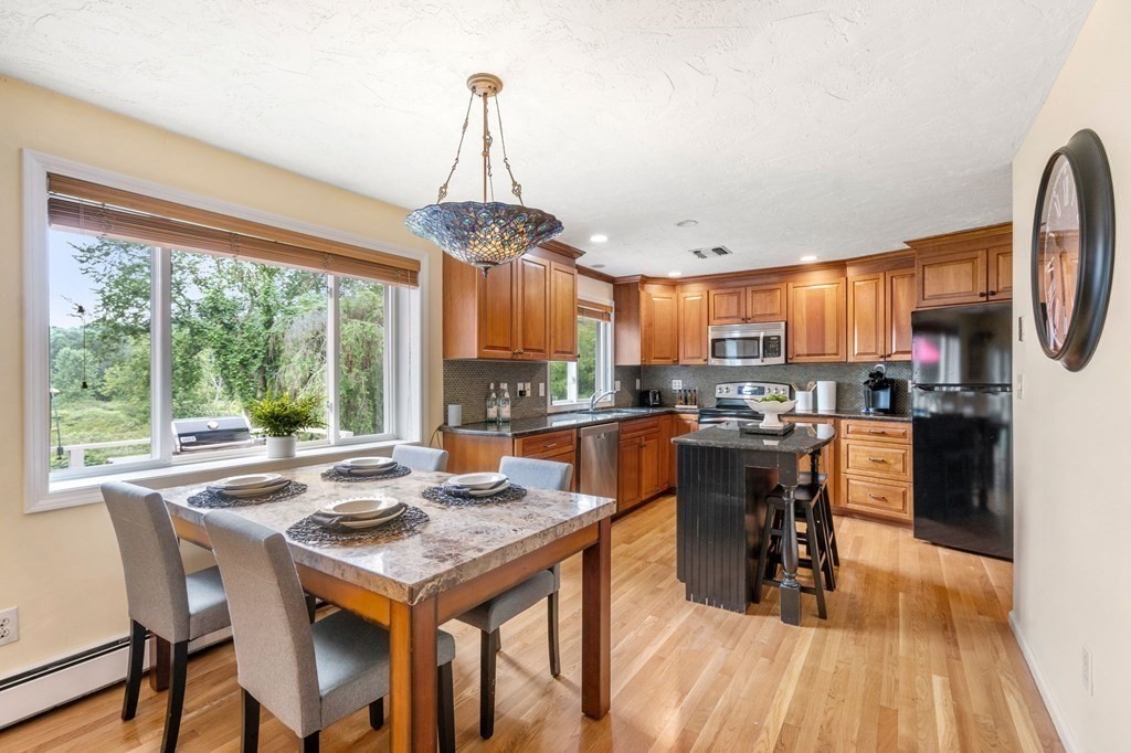 96 Bridge Street Medfield, MA 02052 - Photo 5 of 41 a view of a dining room and livingroom with furniture wooden floor a chandelier