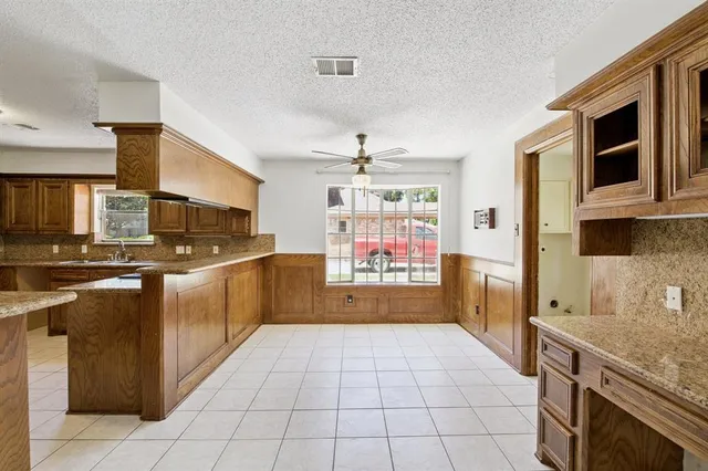 a kitchen with stainless steel appliances granite countertop a stove a sink and a microwave