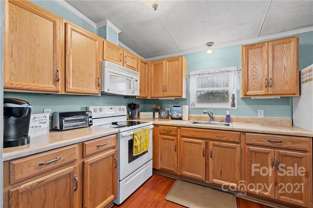4507 Morgan Mill Road Monroe, NC 28110 - Photo 11 of 33 a kitchen with stainless steel appliances granite countertop a sink a stove cabinets and a window