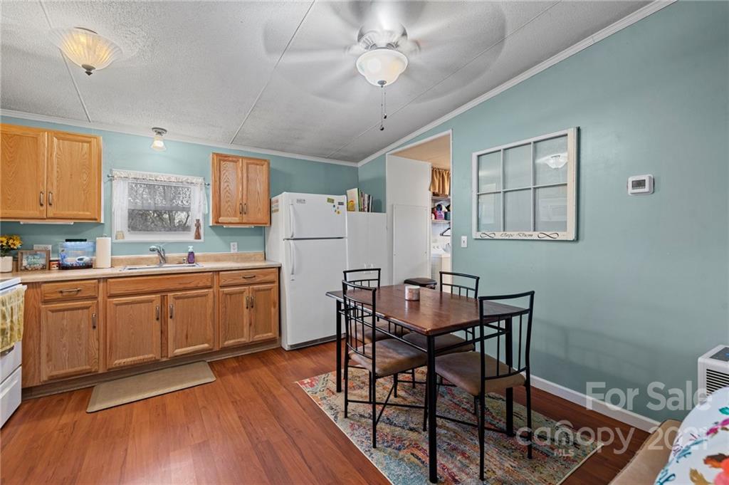 4507 Morgan Mill Road Monroe, NC 28110 - Photo 12 of 33 a kitchen with a dining table chairs refrigerator and cabinets