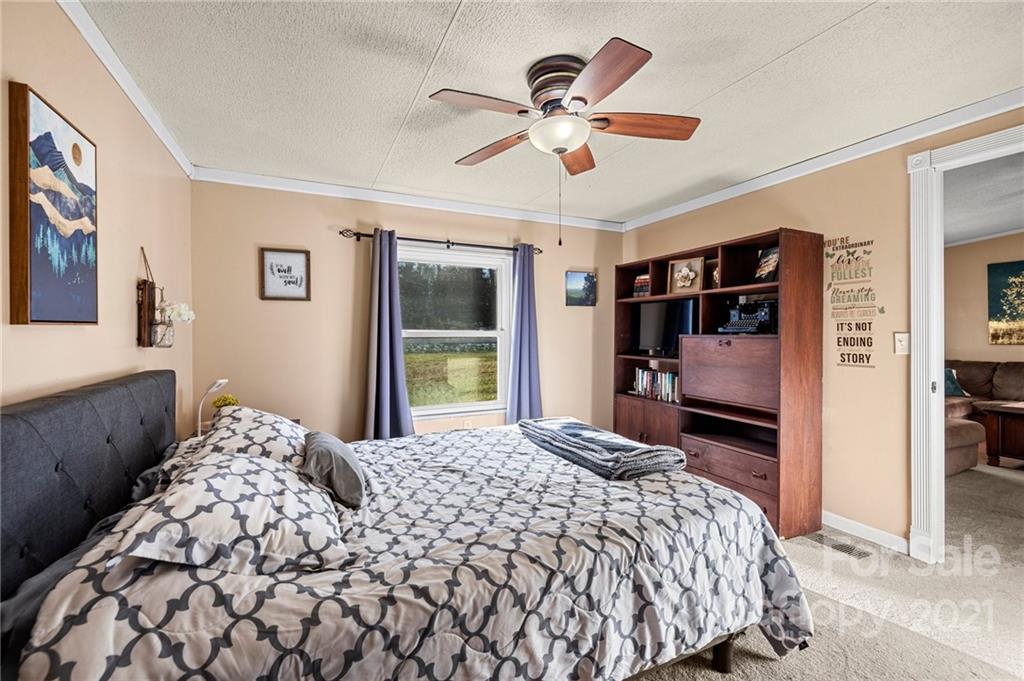 4507 Morgan Mill Road Monroe, NC 28110 - Photo 17 of 33 a bedroom with a large bed and a chandelier