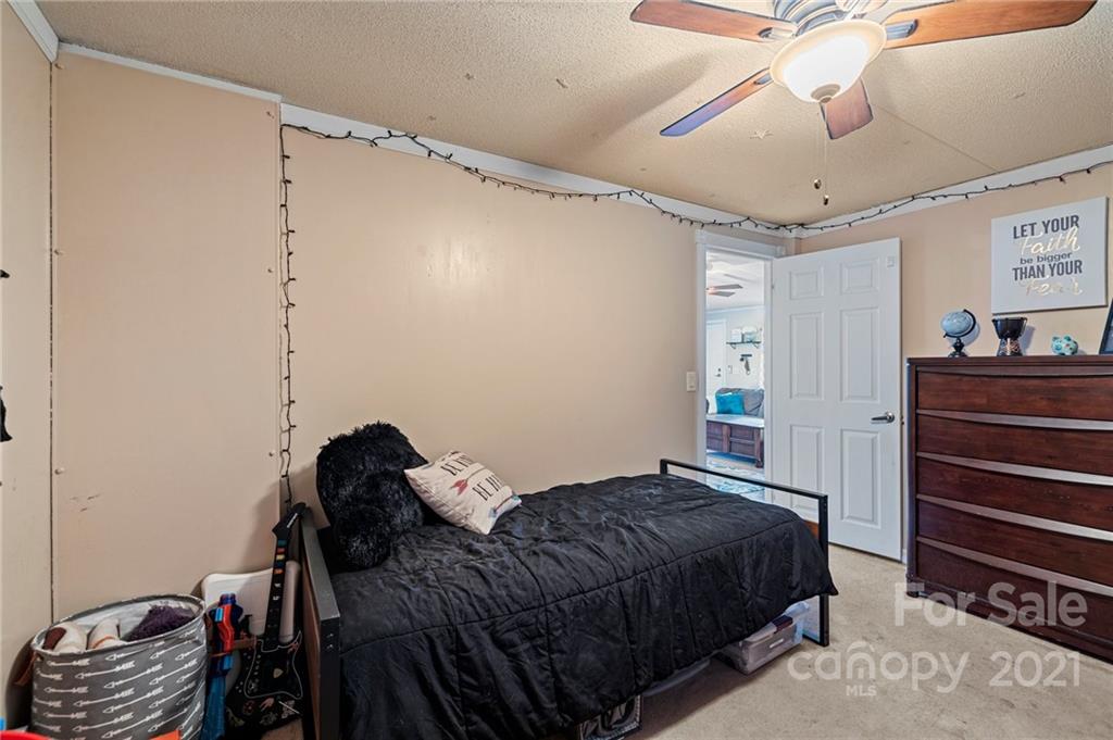 4507 Morgan Mill Road Monroe, NC 28110 - Photo 24 of 33 a bedroom with a bed and a chandelier