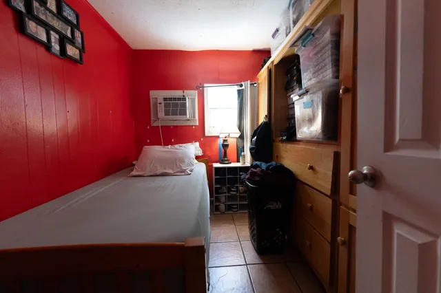 a bed room with a bed next to a window