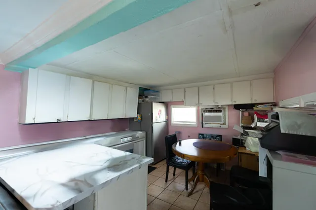 a kitchen with a table chairs refrigerator and cabinets