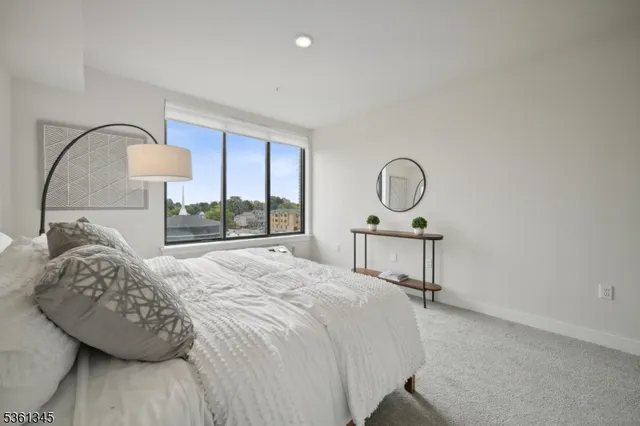 a bedroom with a bed a mirror and a window