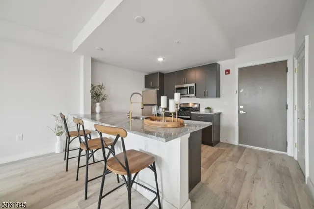 a kitchen with stainless steel appliances kitchen island granite countertop a sink and cabinets