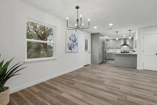 a view of a room with wooden floor and a ceiling fan