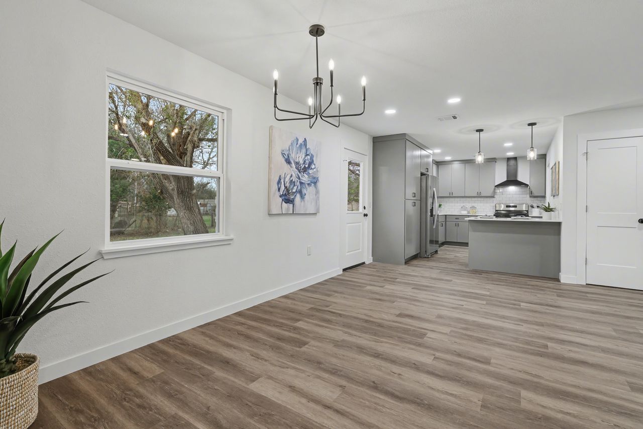 2103 Fordham Cove Austin, TX 78723 - Photo 14 of 36 a view of a hallway with wooden floor and a chandelier